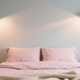 Cozy small bedroom featuring stylish wall lamps for small bedrooms on either side of the bed.