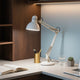 A well-lit home office setup demonstrating the whole-house lighting guide with a desk lamp and laptop.